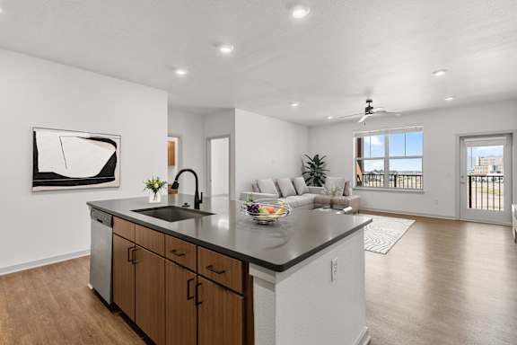 A modern kitchen with a large island and a painting on the wall.