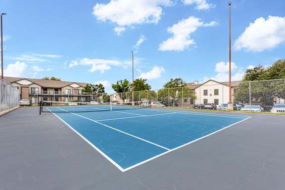 A tennis court with a blue surface and white lines.
