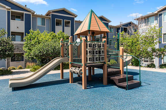 A playground with a slide and a wooden structure.
