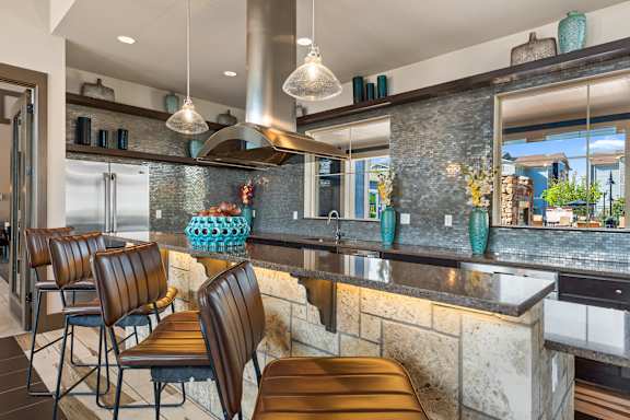 A kitchen with a bar area and chairs.