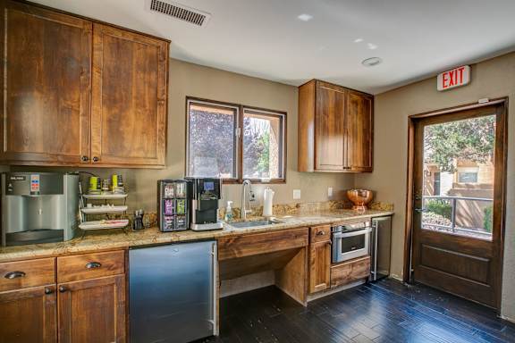 A kitchen with wooden cabinets and a black fridge.