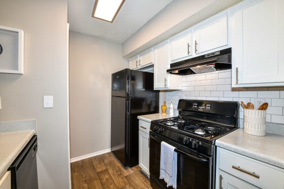 a kitchen with white cabinets and black appliances at 670 Thornton, Lithia Springs, Georgia