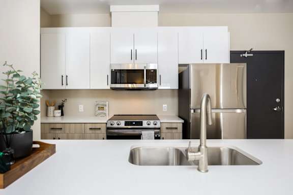 A modern kitchen with stainless steel appliances and white cabinets.