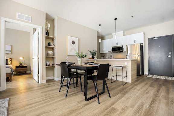 A modern kitchen with a dining table set for two.