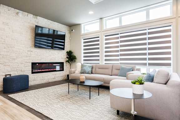 A living room with a fireplace, a sofa, a coffee table, and a television.