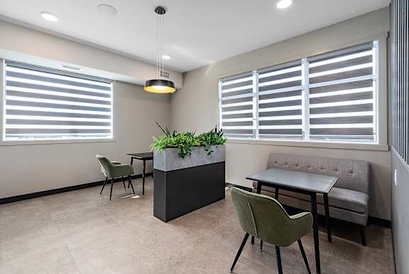 a seating area with tables and chairs and a potted plant