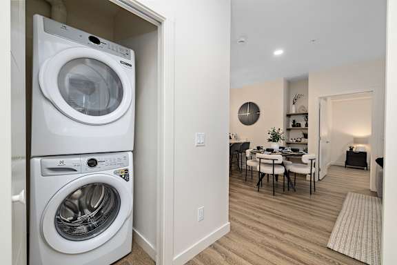 a washer and dryer in a living room next to a dining room table