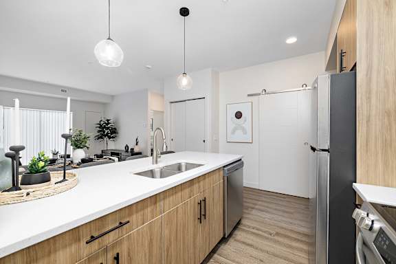 a kitchen with a large island and a stainless steel refrigerator