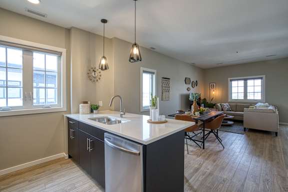 A kitchen with a dining table and chairs in the background.