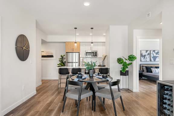 A modern dining room with a table set for four. at Podium Apartments, Calgary, AB