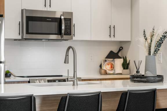 A modern kitchen with a stainless steel microwave above the counter.