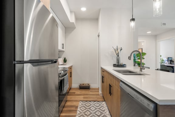 a renovated kitchen with stainless steel appliances and white counter tops