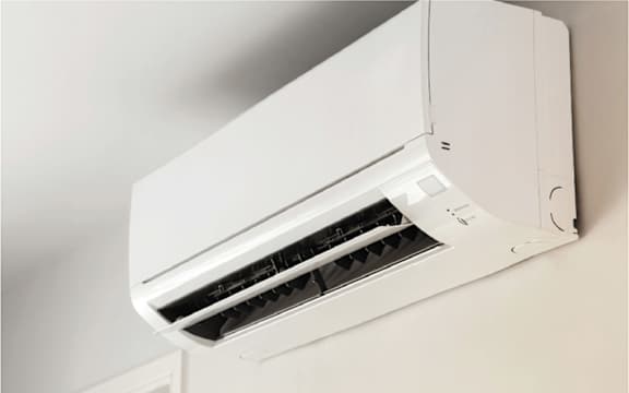 A white air conditioner unit mounted on a wall.