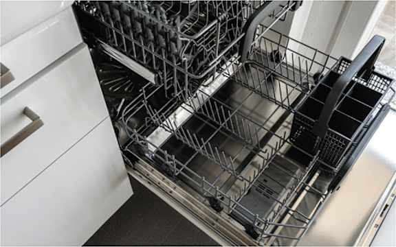 A close up of a dishwasher with the door open.