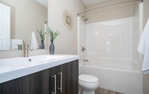 A bathroom with a white sink, a toilet, and a glass shower door.
