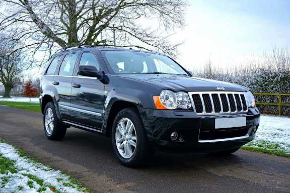 A black Jeep is parked on a snowy road.