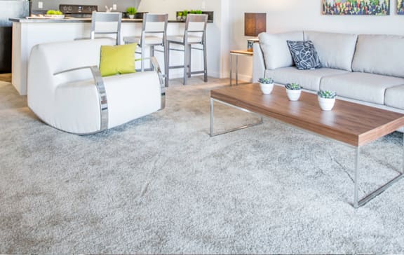 A grey couch with yellow pillows and a wooden coffee table.