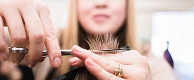 A person is cutting hair with scissors.
