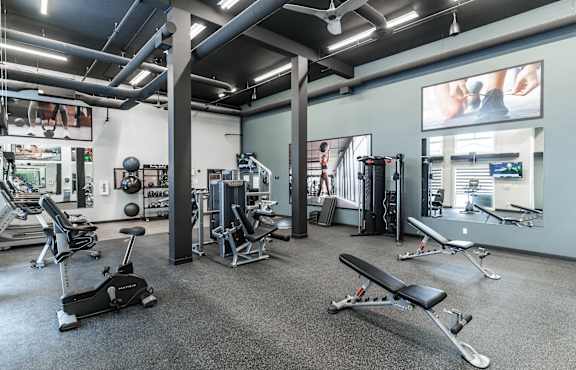 A gym with a variety of equipment including weights and machines.