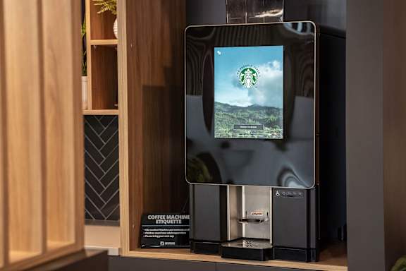 A coffee machine with a screen displaying a green landscape. at Skyway Apartments, Alberta, T3B 5V6