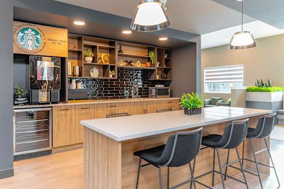 A Starbucks coffee shop interior with a counter and chairs.at Vibe Apartments at Arbour Lake, Calgary Alberta