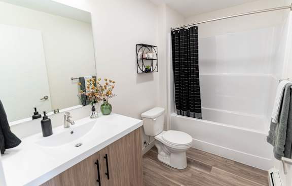 A white sink with a black towel on the counter.at Vibe Apartments at Arbour Lake, Alberta