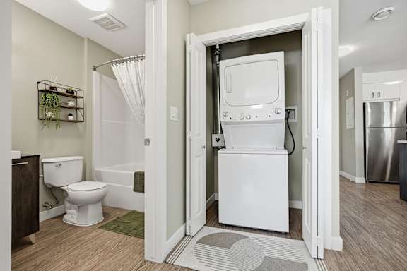 A white bathroom with a toilet, sink, and shower.