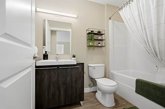 A white toilet sits next to a white sink in a bathroom.