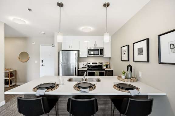 A modern kitchen with a dining table set for four.