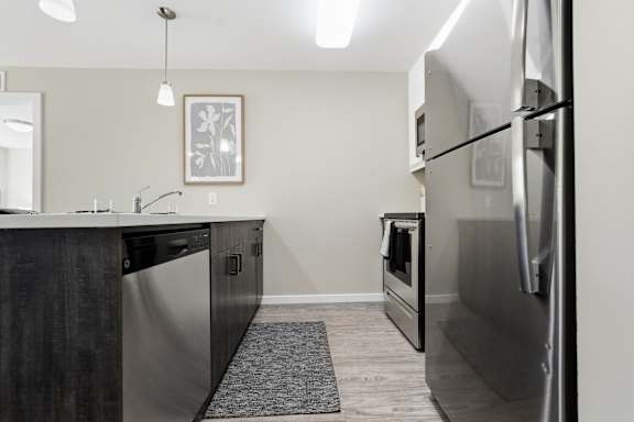 A modern kitchen with a refrigerator on the right side.