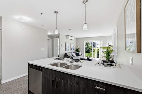 A modern kitchen with a large island and a dishwasher.