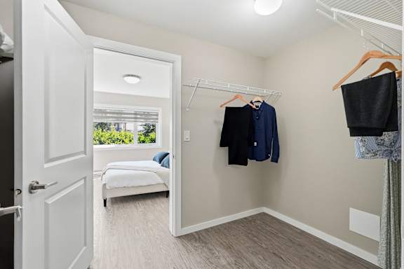 A bedroom with a bed, a wardrobe, and a window.