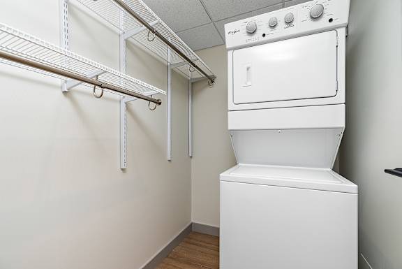A white oven and dryer in a small laundry room.at Raymond Block, Edmonton