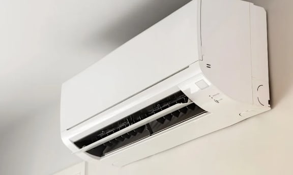A white air conditioner unit is mounted on a wall.