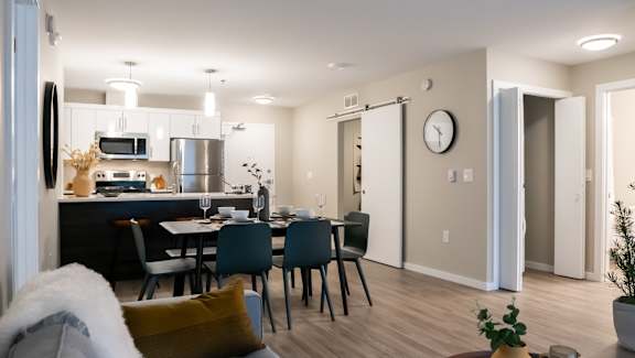 A modern kitchen with a dining table set for four.