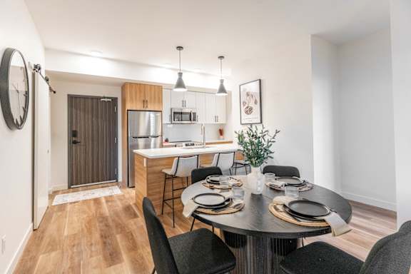 A modern dining room with a round table set for four.at The Artisan at Rangeview, Calgary, Alberta