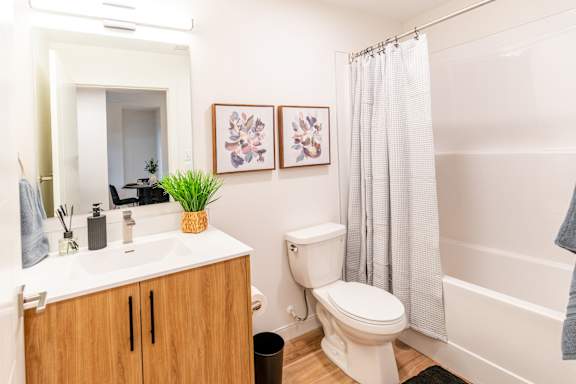 A bathroom with a toilet, sink, and shower.at The Artisan at Rangeview, Calgary, Alberta