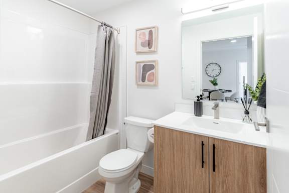 A white toilet sits in a bathroom next to a white sink.