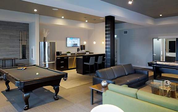 A modern living room with a pool table and a television.