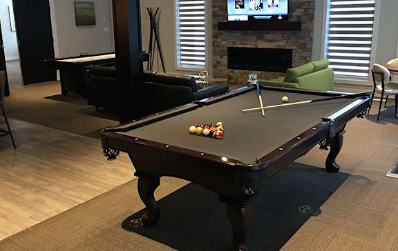 A pool table in a room with a television and a fireplace.