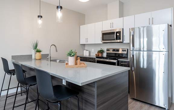 A modern kitchen with a large island and stainless steel appliances.