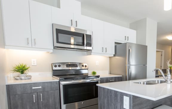 A modern kitchen with a stainless steel refrigerator, oven, and microwave.