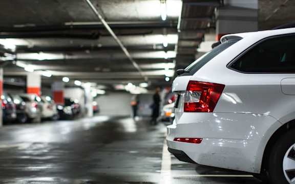 Underground parking garage with white car at Mac and Mullen Apartments, Edmonton, Alberta