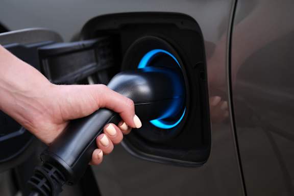 a hand holding a gas pump nozzle at Vibe Apartments at Arbour Lake in Calgary, AB, T3G 4J2