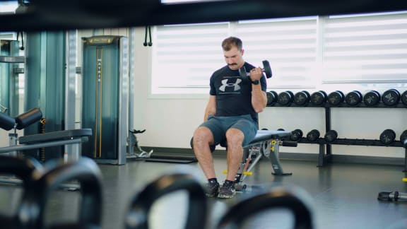 a man lifting a dumbbell in a gym