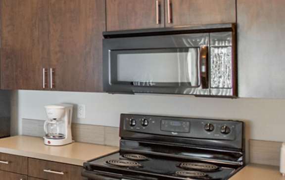 A black stove top oven with a microwave above it.
