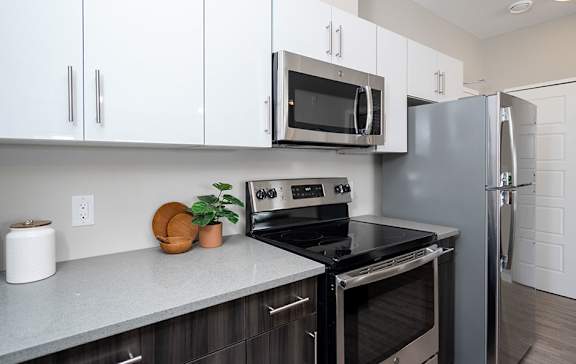 A kitchen with a black stove top oven and a black microwave above it.