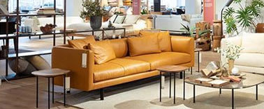A living room with a brown leather couch and a coffee table.