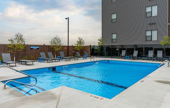 A large blue swimming pool with a depth marker reading 5.5 meters.