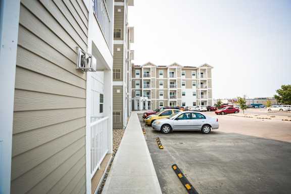 A car is parked in a parking lot next to a building.